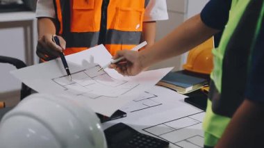 Ofisteki planlarla çalışan Asyalı mühendis