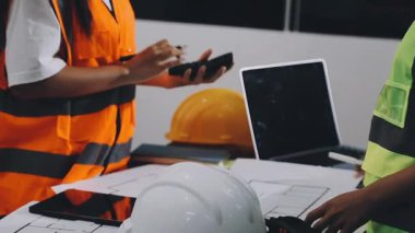 İnşaat projesinde çalışan mimar ve mühendis. İnşaat mühendisi, mühendis, mühendis veya inşaat işçisi bilgisayar ve tablet Compu ile inşaat alanında çalışıyor