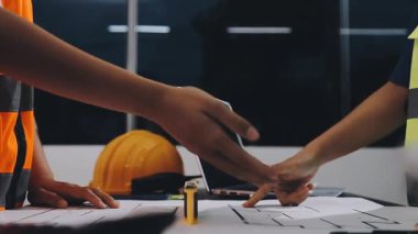 İki genç iş adamı masadaki ofiste el sıkışıyor..