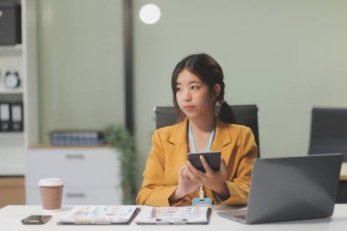 Modern ofis odasında dizüstü bilgisayarla projesinde çalışan çekici genç bir iş kadını..