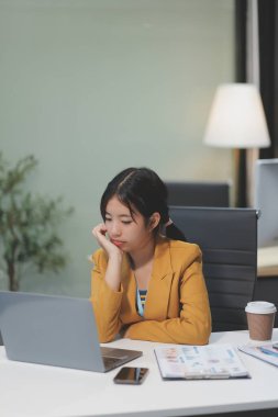 Asyalı kadınlar dizüstü bilgisayarda çalışırken streslidirler, ofiste başı ağrıyan Asyalı iş kadını, işte hasta hissederler, yer kopyalayabilirler.