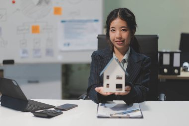 Emlakçılar, konut modellerini müşterilere ayrıntılı bir şekilde anlatma, evler ve satın alma kredileri hakkında bilgi verme ve sunma konularında açıklar. Gayrimenkul ticareti.