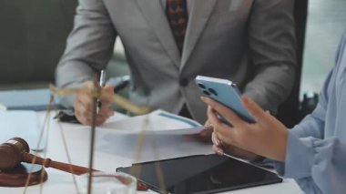 Ofiste iş planı tartışılırken elinde akıllı telefon tutan iş kadını