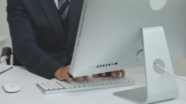 Ofis masasında dizüstü bilgisayarla çalışan iş adamı