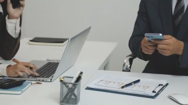 Takım elbiseli genç işadamı ofiste çalışıyor.