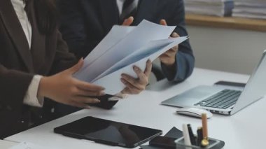 İş adamı ve kadın elleri iş belgesini tartışıyor