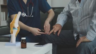 Doktor hastanın tansiyonunu ölçüyor.