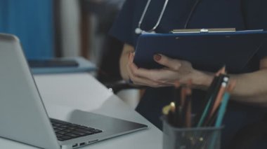 Kadın doktor elinde bir tablet tutuyor.