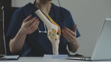 Stetoskop ve dizüstü bilgisayarı olan beyaz tişörtlü bir doktor.