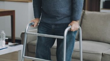 Elinde koltuk değneği tutan kıdemli bir adam.