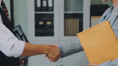 Belgeleri tutan ve ofiste el sıkışan işadamları