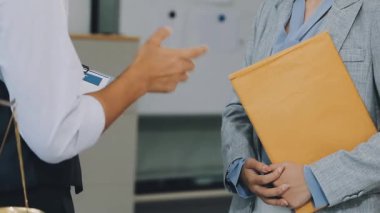 İşadamları ofiste belgeleri imzalarken el sıkışıyorlar.