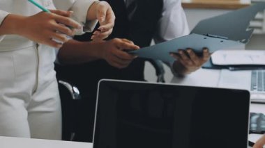 İş yerinde elinde kalem ve kağıda yazı tutan genç bir bayan.