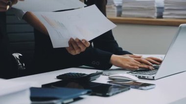 Genç iş kadını ofiste çalışıyor, işyerinde oturuyor.