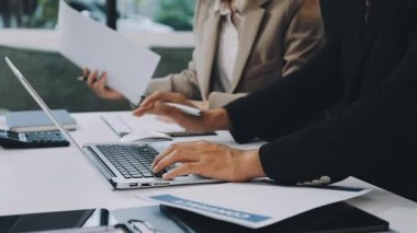 İşadamları dizüstü bilgisayarda çalışıyor ve iş planlarını tartışıyorlar.