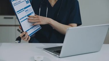 Doktor laptop ve steteskop kullanıyor.