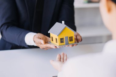 Bir çift satın almak için bir konut projesine yaklaşıyor ve bir konut projesindeki satıcıyla detayları ve tavsiyeleri tartışıyorlar. Çiftlerle emlak ticareti..