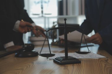Danışmanlık ve erkek avukatlar konferansı ve profesyonel iş kadını avukatlık bürosunda çalışıyor ve tartışıyorlar. Hukuk kavramları, Yargıç Tokmak adalet terazisiyle..