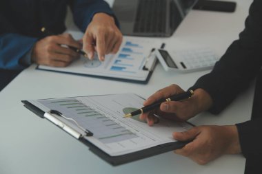 İş adamlarından oluşan bir ekip, pazarlama planı, piyasa araştırma raporları ve gelir istatistikleri, Mali ve Muhasebe kavramının verilerini analiz etmek üzere toplanıyor..