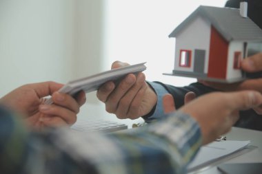 Emlakçı ve müşteri ev, sigorta ya da emlak satın almak için sözleşme imzalarlar. Ev kiralarlar, sigorta yaptırırlar, emlak veya emlak kredisi alırlar..