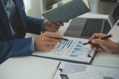 İş adamlarından oluşan bir ekip, pazarlama planı, piyasa araştırma raporları ve gelir istatistikleri, Mali ve Muhasebe kavramının verilerini analiz etmek üzere toplanıyor..