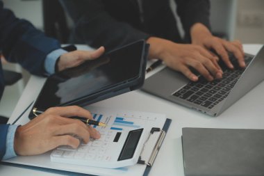 İş adamlarından oluşan bir ekip, pazarlama planı, piyasa araştırma raporları ve gelir istatistikleri, Mali ve Muhasebe kavramının verilerini analiz etmek üzere toplanıyor..