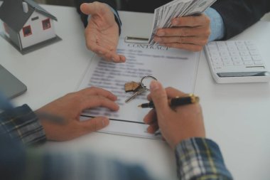 Emlakçı ve müşteri ev, sigorta ya da emlak satın almak için sözleşme imzalarlar. Ev kiralarlar, sigorta yaptırırlar, emlak veya emlak kredisi alırlar..