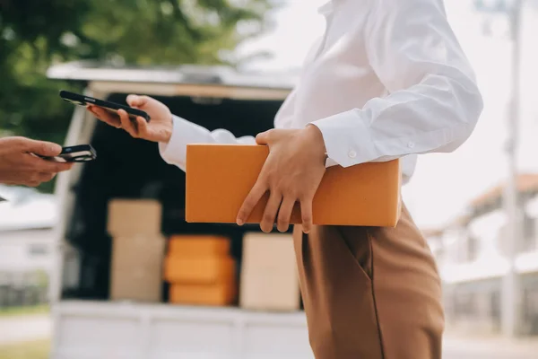 Asian Woman Receiving Product from delivery man at Home, Young Owner Woman Order Product from Smartphone Application, Woman with Online Business or SME Concept.