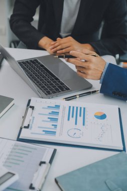 İş adamlarından oluşan bir ekip, pazarlama planı, piyasa araştırma raporları ve gelir istatistikleri, Mali ve Muhasebe kavramının verilerini analiz etmek üzere toplanıyor..