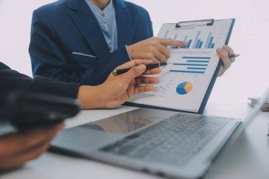 İş adamlarından oluşan bir ekip, pazarlama planı, piyasa araştırma raporları ve gelir istatistikleri, Mali ve Muhasebe kavramının verilerini analiz etmek üzere toplanıyor..