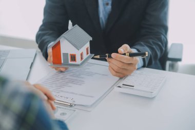 Emlakçı ve müşteri ev, sigorta ya da emlak satın almak için sözleşme imzalarlar. Ev kiralarlar, sigorta yaptırırlar, emlak veya emlak kredisi alırlar..