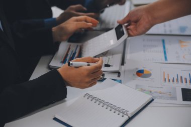 Finansal analistler, şirketlerin başarılı takım çalışmalarının sonuçlarını gösteren bir toplantıda bir dijital tablet planlama yatırım projesinin ticari mali raporlarını analiz ediyorlar..