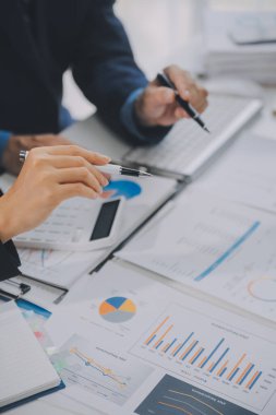 Finansal analistler, şirketlerin başarılı takım çalışmalarının sonuçlarını gösteren bir toplantıda bir dijital tablet planlama yatırım projesinin ticari mali raporlarını analiz ediyorlar..