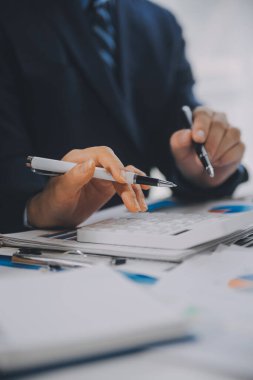 Finansal analistler, şirketlerin başarılı takım çalışmalarının sonuçlarını gösteren bir toplantıda bir dijital tablet planlama yatırım projesinin ticari mali raporlarını analiz ediyorlar..