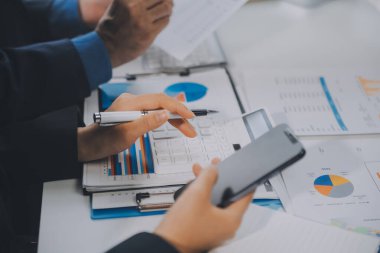 Finansal analistler, şirketlerin başarılı takım çalışmalarının sonuçlarını gösteren bir toplantıda bir dijital tablet planlama yatırım projesinin ticari mali raporlarını analiz ediyorlar..