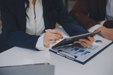 Finansal analistler, şirketlerin başarılı takım çalışmalarının sonuçlarını gösteren bir toplantıda bir dijital tablet planlama yatırım projesinin ticari mali raporlarını analiz ediyorlar..