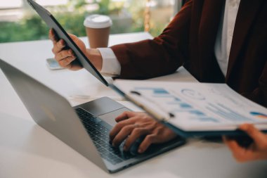 Finansal analistler, şirketlerin başarılı takım çalışmalarının sonuçlarını gösteren bir toplantıda bir dijital tablet planlama yatırım projesinin ticari mali raporlarını analiz ediyorlar..