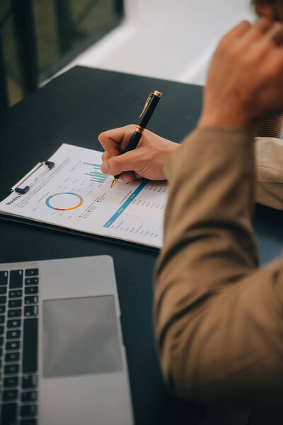 Entrepreneur Asian businessman and businesswoman discussing new business project in tablet in modern Meeting In Modern Office, Asian business casual concept.