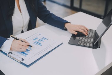 Finansal analistler, şirketlerin başarılı takım çalışmalarının sonuçlarını gösteren bir toplantıda bir dijital tablet planlama yatırım projesinin ticari mali raporlarını analiz ediyorlar..