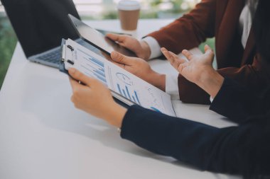 Finansal analistler, şirketlerin başarılı takım çalışmalarının sonuçlarını gösteren bir toplantıda bir dijital tablet planlama yatırım projesinin ticari mali raporlarını analiz ediyorlar..