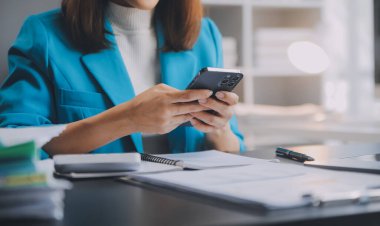 Bir ofis masası, vergi, rapor, muhasebe, istatistik ve analitik araştırma kavramında matematik finansmanı için hesap makinesi ve dizüstü bilgisayar kullanan Asyalı İş kadını