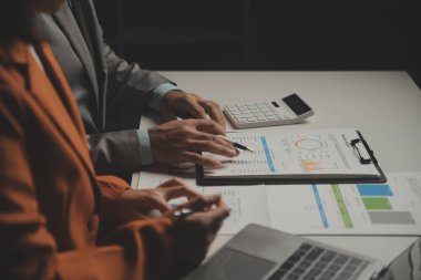 İş ekibi ile yeni başlangıç planı ve tartışma için proje bilgilerini dizüstü bilgisayar ve dijital tablet ile mali strateji bir modern iş salonda çalışıyor.