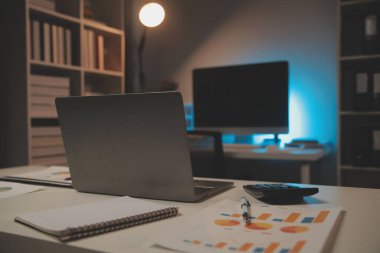Laptop ve evraklar konferans masasında.