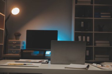Laptop ve evraklar konferans masasında.