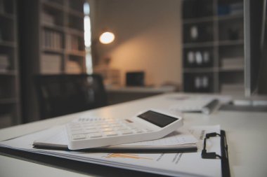 Laptop ve evraklar konferans masasında.