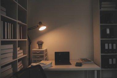 Laptop ve evraklar konferans masasında.