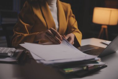 İş kadını, ofis ve iş geçmişinde, vergi, muhasebe, istatistik ve analitik araştırma kavramında matematik finansmanı için hesap makinesi kullanıyor.