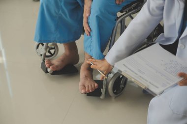 young asian physical therapist working with senior woman on walking with a walker
