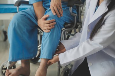 young asian physical therapist working with senior woman on walking with a walker