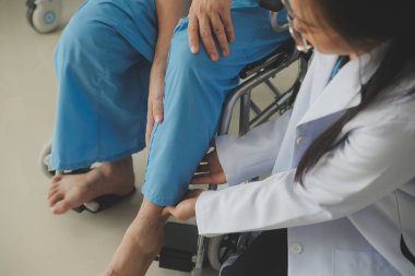 young asian physical therapist working with senior woman on walking with a walker